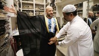 Seorang pria mencoba jubah Bisht di Souq Waqif Bazaar, Doha, Qatar, Rabu (21/12/2022). (Ashraf Amra/Anadolu Agency/Getty Images)  