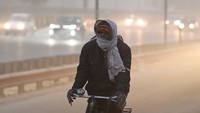Musim dingin melanda sebagian wilayah di India. Warga tetap beraktivitas di tengah dingin dan kabut. (Vipin Kumar/Getty Images)