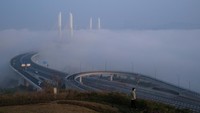 Warga tampak melihat kabut menyelimuti kawasan Chongqing, China.
