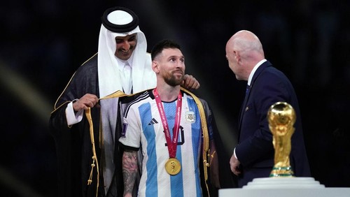 Emir of Qatar, Sheikh Tamim bin Hamad Al Thani dresses Argentinas Lionel Messi with traditional Arab bisht ahead of the Trophy presentation as FIFA President Gianni Infantino looks on following the FIFA World Cup final at Lusail Stadium, Qatar. Picture date: Sunday December 18, 2022. (Photo by Mike Egerton/PA Images via Getty Images)