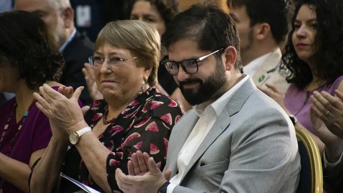 Chilean President Gabriel Boric, right, and former President Michelle Bachelet, applaud during a ceremony marking human rights month in Santiago, Chile, Monday, Dec. 12, 2022. (AP Photo/Matias Basualdo)