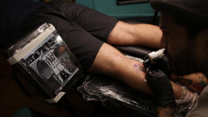 Seniman Argentina Kebanjiran Order Tato Messi Fermin Robilotte, 27, gets a tattoo of Argentina's soccer star Lionel Messi, after Argentina's soccer national team won FIFA World Cup Qatar 2022, in Buenos Aires, Argentina, December 21, 2022. REUTERS/Tomas Cuesta NO RESALES. NO ARCHIVES