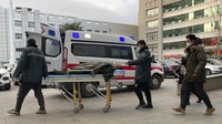 Petugas medis mendorong seorang pria melewati ambulans di Rumah Sakit Pusat No. 2 Baoding di kota Zhuozhou di provinsi Hebei, China utara pada Rabu(21/12/2022).  