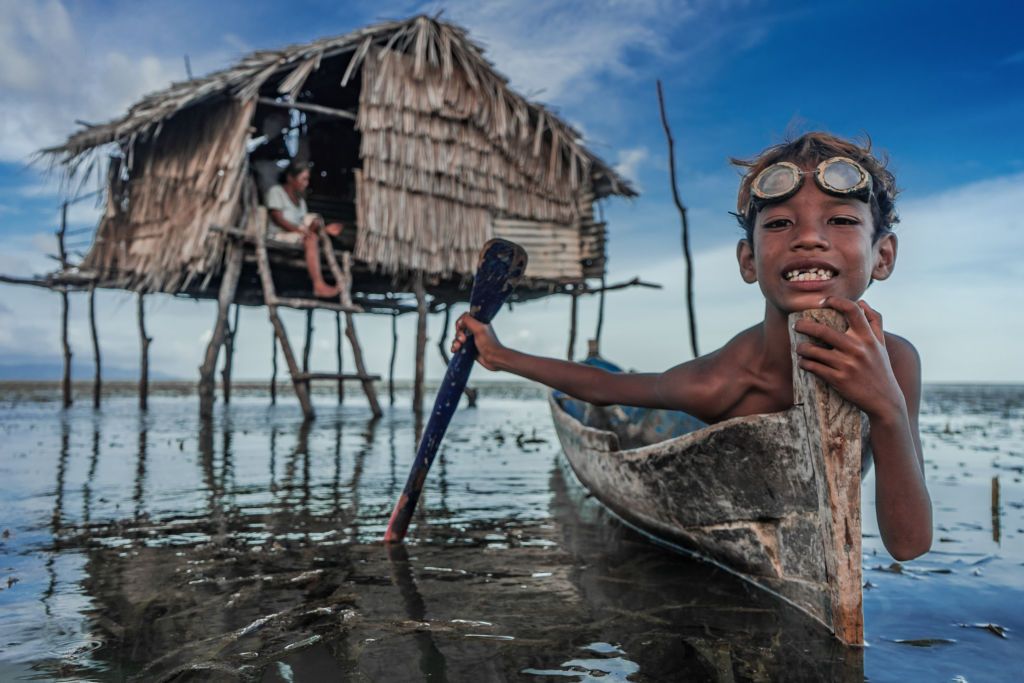 BUTON, SOUTH EAST SULAWESI, INDONESIA - 2020/10/01: Dimas Saputra (10 years old) is seen posing with his favorite boat right in front of his house. The life of the Bajo tribe, from birth to adulthood, is dependent on the sea. Everything is done there, from looking for food to all life activities carried out in the sea. Dimas Saputra is one of the many children who became an accomplished bajo child with extraordinary diving skills at a young age. Since childhood, his father Muhammad Ajran (36 years old) and his mother Sunarti (35 years old) have been accustomed to knowing and uniting with nature. (Photo by Andry Denisah/SOPA Images/LightRocket via Getty Images)