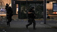 Polisi anti huru hara mengambil posisi selama bentrokan. Kerusuhan pecah sekitar pukul 20.00 waktu setempat.  