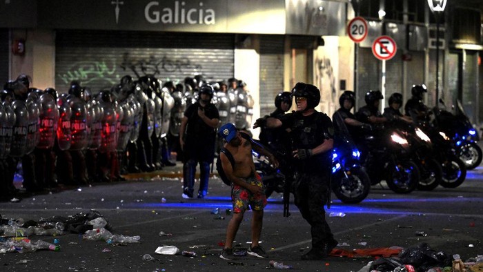 Riot police clashes with fans of Argentina following the celebration of the team's arrival from the Qatar 2022 World Cup tournament, which left millions disappointed when an open-top bus parade had to be abandoned due to the massive crowds, on December 20, 2022, in the surroundings of the Obelisk in Buenos Aires. (Photo by Luis ROBAYO / AFP) (Photo by LUIS ROBAYO/AFP via Getty Images)