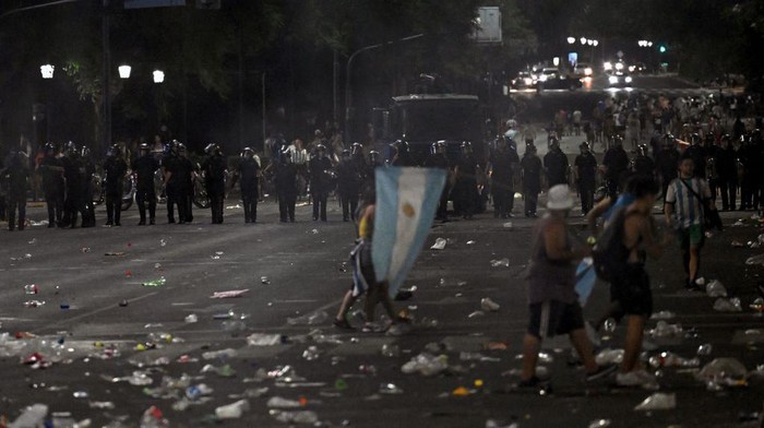 Suporter dan Polisi Bentrok Saat Perayaan Argentina Juara Dunia Riot police clashes with fans of Argentina following the celebration of the team's arrival from the Qatar 2022 World Cup tournament, which left millions disappointed when an open-top bus parade had to be abandoned due to the massive crowds, on December 20, 2022, in the surroundings of the Obelisk in Buenos Aires. (Photo by Luis ROBAYO / AFP) (Photo by LUIS ROBAYO/AFP via Getty Images)