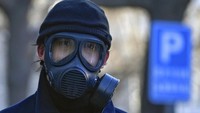 Kasus COVID-19 yang menggila di China membuat warganya khawatir tertular penyakit mematikan itu. Bahkan mereka sampai pakai masker gas beracun agar tidak tertular. (Foto: AP/Andy Wong)