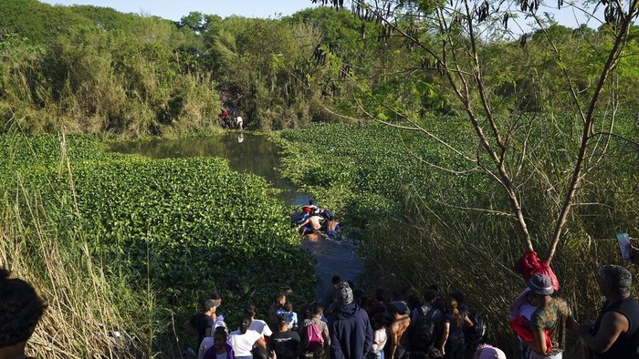Venezuelan migrants cross a river towards U.S territory from a river bank in Matamoros, Mexico, Thursday, Dec. 22, 2022. (AP Photo/Fernando Llano)