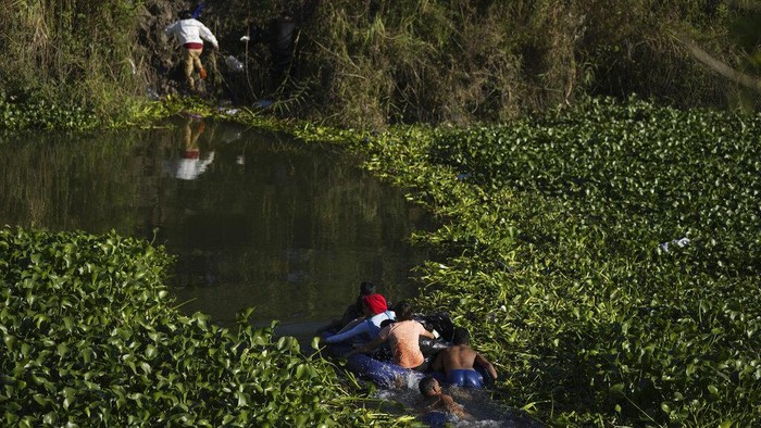 Venezuelan migrants cross a river towards U.S territory from a river bank in Matamoros, Mexico, Thursday, Dec. 22, 2022. (AP Photo/Fernando Llano)