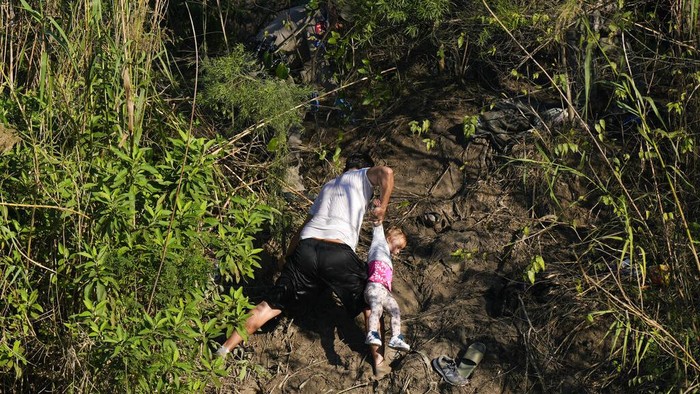 Venezuelan migrants cross a river towards U.S territory from a river bank in Matamoros, Mexico, Thursday, Dec. 22, 2022. (AP Photo/Fernando Llano)