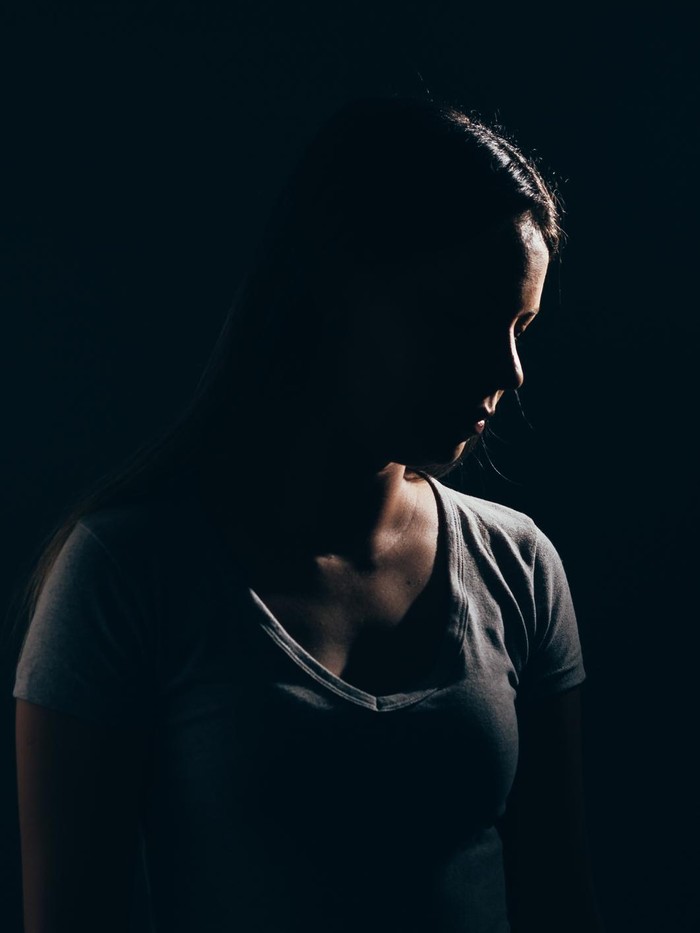 Ilustrasi Wanita Sedih Sad woman in dark room. Depression and anxiety disorder concept