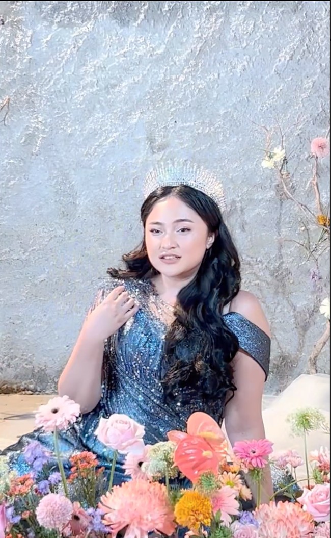 Marshanda tampil mengenakan gaun berpotongan sabrina berwarna biru tua lengkap dengan mahkota di kepalanya. Ia juga mengenakan ekstensi rambut panjang hitam yang dikeriting. Foto: Instagram/@coutier_the