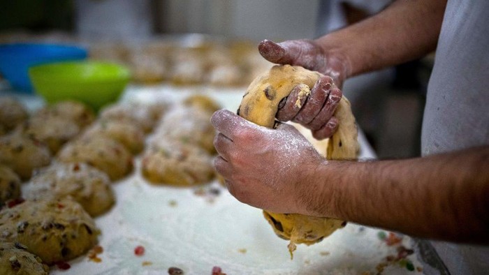 Menginti Pembuatan Bolo Rei, Kue Tradisional Sajian Khas Natal di Portugal A baker puts crystallized fruits ontop of a