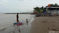Pengunjung berenang di Wisata Pantai Tirta Ayu, Kecamatan Balongan, Kabupaten Indramayu. Lembutnya pasir dan ombak yang kecil cocok untuk bermain anak. Namun tetap dalam pengawasan orang tua. (Foto: Sudedi Rasmadi/detikJabar)
