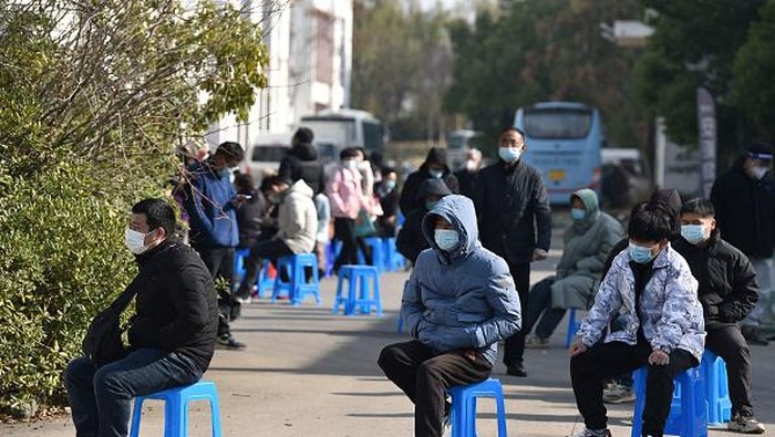 People queue outside a makeshift clinic transformed from a bus in Nanjing, in Chinas eastern Jiangsu province on December 21, 2022. - China OUT (Photo by AFP) / China OUT (Photo by STR/AFP via Getty Images)