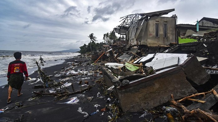 DAMPAK CUACA EKSTREM DI MATARAM Sejumlah warga melintas di dekat bangunan rumah yang roboh di Lingkungan Mapak Indah, Kelurahan Jempong Baru, Mataram, NTB, Sabtu (24/12/2022). Gelombang tinggi yang disertai angin kencang yang terjadi sejak Jumat (23/12) di daerah tersebut mengakibatkan belasan rumah warga yang berada di pesisir pantai rusak dan roboh tergerus abrasi. ANTARA FOTO/Ahmad Subaidi/YU