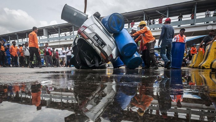 Sejumlah petugas mengevakuasi mobil yang jatuh ke laut di Dermaga II Pelabuhan Merak, Kota Cilegon, Banten, Sabtu (24/12/2022). Kecelakaan yang diduga akibat kelalaian petugas penjaga rem pintu kapal tersebut menyebabkan satu unit mobil tenggelam ke laut dan dua orang dirawat di rumah sakit. ANTARA FOTO/Muhammad Bagus Khoirunas/YU