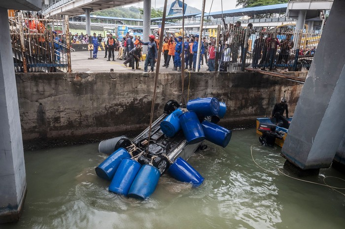 Sejumlah petugas mengevakuasi mobil yang jatuh ke laut di Dermaga II Pelabuhan Merak, Kota Cilegon, Banten, Sabtu (24/12/2022). Kecelakaan yang diduga akibat kelalaian petugas penjaga rem pintu kapal tersebut menyebabkan satu unit mobil tenggelam ke laut dan dua orang dirawat di rumah sakit. ANTARA FOTO/Muhammad Bagus Khoirunas/YU