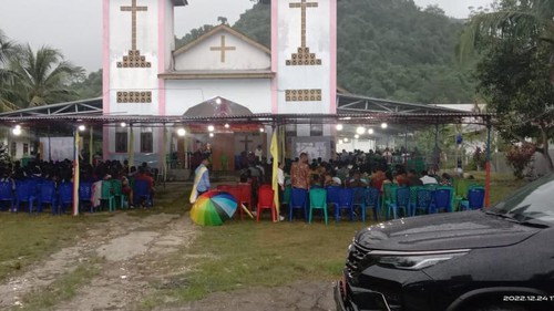Umat kristiani menerobos hujan memasuki gereja Katolik di Merombok, Labuan Bajo. (IST)