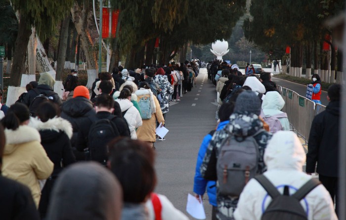 1245807167 YANTAI, CHINA - DECEMBER 24, 2022 - Candidates wait in line for the 2023 national postgraduate entrance exam at a test center in Yantai, East China's Shandong province, Dec. 24, 2022. (Photo credit should read CFOTO/Future Publishing via Getty Images)