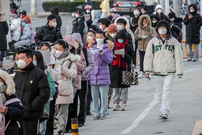 1245807167 YANTAI, CHINA - DECEMBER 24, 2022 - Candidates wait in line for the 2023 national postgraduate entrance exam at a test center in Yantai, East China's Shandong province, Dec. 24, 2022. (Photo credit should read CFOTO/Future Publishing via Getty Images)
