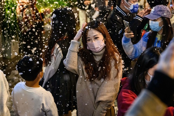 GUANGZHOU, CHINA - DECEMBER 24: People have fun with the snow machine ahead of the Christmas day and as the new year approaches in Guangzhou, China on December 24, 2022. (Photo by Stringer/Anadolu Agency via Getty Images)