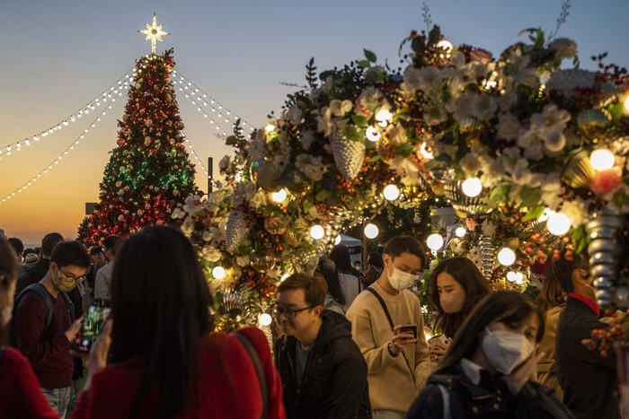 People wearing face mask posing for a photo at a  Christmas Display at the West Kowloon Cultural District on December 24, 2022 in Hong Kong, China. Today is Christmas Eve (Photo by Vernon Yuen/NurPhoto via Getty Images)
