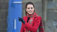 Kate Middleton tampil anggun dengan scarf dan gaun merah. Foto: POOL/AFP via Getty Images/HEATHCLIFF OMALLEY