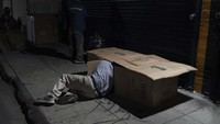 David Hernandez, seorang pria tunawisma berusia 62 tahun, merangkak ke tempat tidurnya yang terbuat dari kardus di Los Angeles, Rabu malam, 14 Desember 2022. AS melaporkan rapor merah ekonomi pada laporan kuartal keduanya (Q2) di tahun 2022. Tercatat PDB Q2 turun pada tingkat tahunan 0,9%. Ini melanjutkan penurunan pada Q1 yang berada di angka 1,6%. Hal ini sendiri dipengaruhi oleh inflasi yang begitu tinggi di negara itu. Pada September 2022, inflasi di negara itu masih tercatat di angka 8,2%. AP Photo/Jae C. Hong.