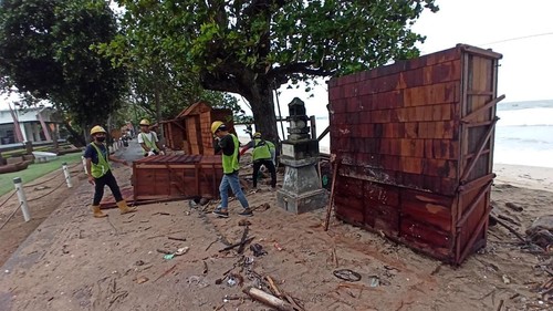 Para pekerja proyek di shelter Kuta saat merapikan gerobak kayu yang porak poranda setelah dihantam gelombang tinggi, Sabtu (24/12/2022).