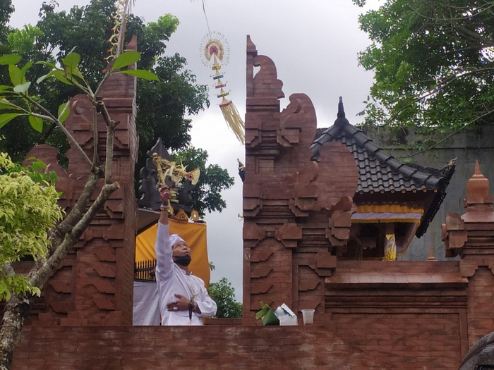 Pawang hujan saat berusaha untuk memindahkan hujan di areal Sentral Tenun Jembrana, Minggu (25/12/2022). (I Putu Adi Budiastrawan/detikBali).