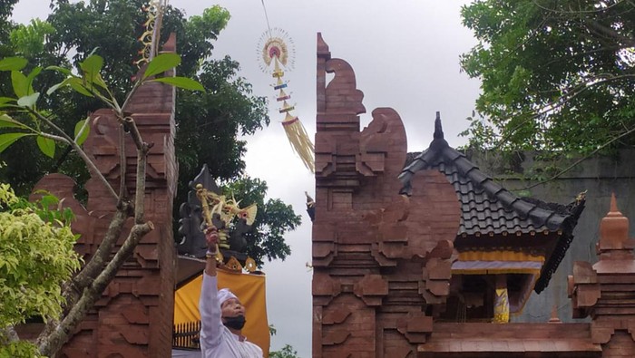 Pawang hujan saat berusaha untuk memindahkan hujan di areal Sentral Tenun Jembrana, Minggu (25/12/2022). (I Putu Adi Budiastrawan/detikBali).