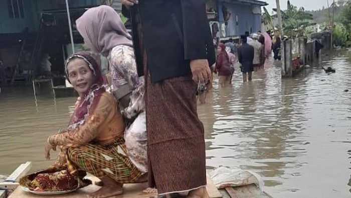 Rombongan pengantar uang panai di Pinrang, Sulsel memakai perahu rakitan gegara banjir.