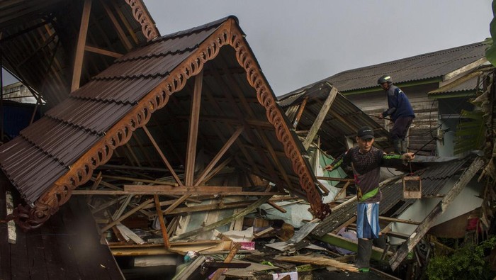 Warga bersama relawan bergotong royong menyingkirkan puing-puing rumah yang roboh di kawasan Sungai Andai, Banjarmasin, Kalimantan Selatan, Minggu (25/12/2022). Angin kencang disertai hujan deras yang melanda Kalimantan Selatan mengakibatkan dua buah bangunan rumah warga serta satu bangunan pesantren roboh di Kota Banjarmasin dan sejumlah pohon tumbang di jalan Ahmad Yani Kabupaten Tapin. ANTARA FOTO/Bayu Pratama S/foc.