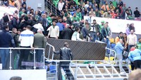 Fans berusaha menyelamatkan orang-orang yang berada di bawah bagian yang hancur. 
