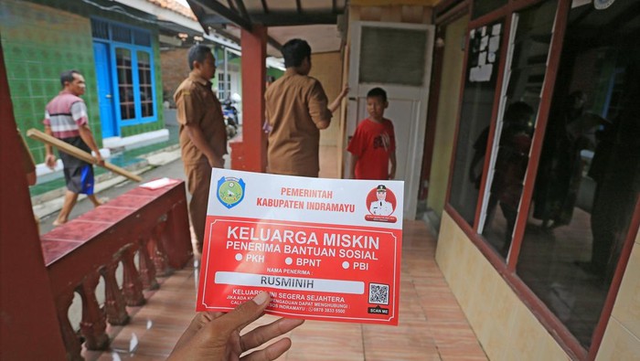 7.777 Rumah Penerima Bansos Ditempelkan Stiker Keluarga Miskin Petugas bersiap menempelkan stiker Keluarga Miskin di salah satu rumah Keluarga Penerima Manfaat (KPM) bantuan sosial di Indramayu, Jawa Barat, Senin (26/12/2022). Sebanyak 7.777 rumah Keluarga Penerima Manfaat (KPM) program bantuan sosial dilabeli dengan stiker Keluarga Miskin oleh Dinas Sosial Kabupaten Indramayu sebagai bentuk transparansi penyaluran bansos supaya tepat sasaran. ANTARA FOTO/Dedhez Anggara/wsj.