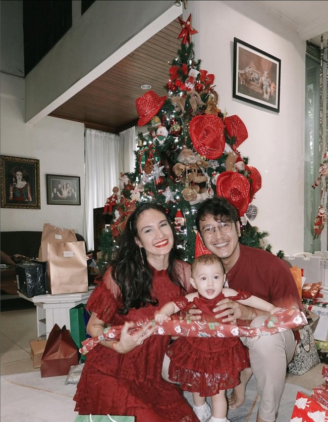 Nadine Chandrawinata memeriahkan kehangatan Natal dengan gaun lace merah, senada dengan sang suami, Dimas Anggara dan buah hati mereka Djiwa. Foto: Instagram