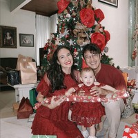 Nadine Chandrawinata memeriahkan kehangatan Natal dengan gaun lace merah, senada dengan sang suami, Dimas Anggara dan buah hati mereka Djiwa. Foto: Instagram