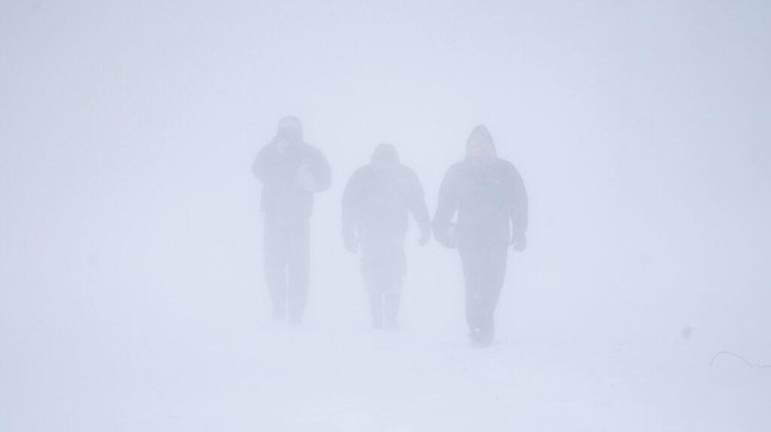 Three men walk down Richmond Avenue in whiteout conditions during a sustained blizzard in Buffalo, N.Y. on Saturday, Dec. 24, 2022. (Derek Gee/The Buffalo News via AP)