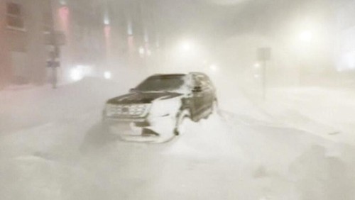 High winds and snow covers the streets and vehicles in Buffalo, N.Y. early Sunday, Dec. 25, 2022.  Millions of people hunkered down in a deep freeze overnight and early morning to ride out the frigid storm that has killed at least 20 people across the United States, trapping some residents inside homes with heaping snow drifts and knocking out power to several hundred thousand homes and businesses. (WKBW via AP)