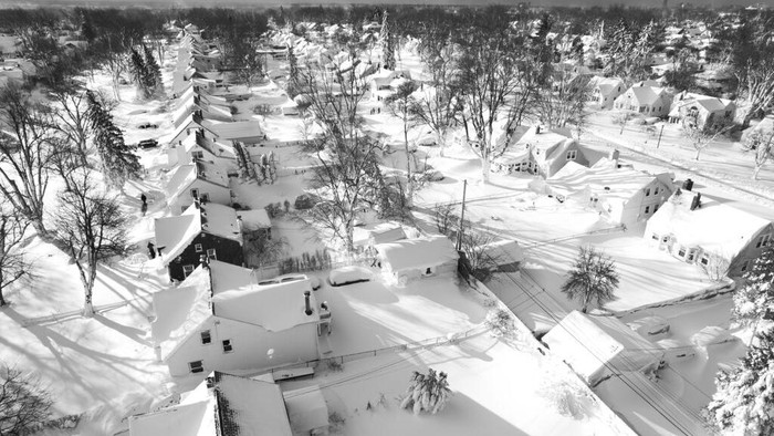 In this drone image, snow blankets a neighborhood, Sunday, Dec. 25, 2022, in Cheektowaga, N.Y. Millions of people hunkered down against a deep freeze Sunday morning to ride out the frigid storm that has killed at least 24 people across the United States and is expected to claim more lives after trapping some residents inside houses with heaping snow drifts and knocking out power to several hundred thousand homes and businesses.(John Waller via AP)