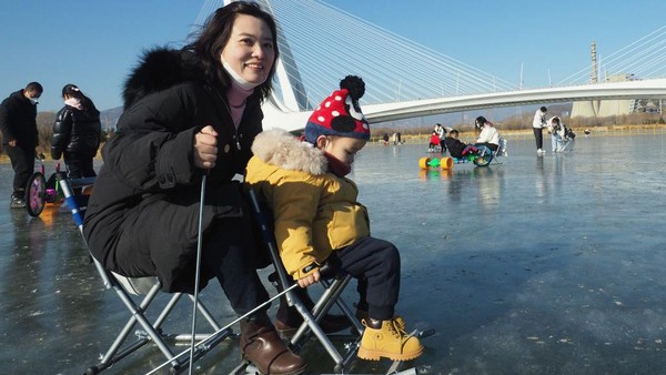 Seorang ibu menemani anaknya bermain ice skating di danau Lianshi yang membeku.