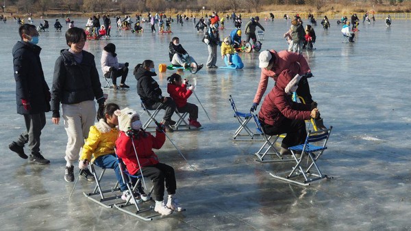 Sejumlah warga memanfaatkan waktu liburan Natal dan Tahun Baru untuk berkunjung ke danau Lianshi, Beijing, China, Sabtu (24/12/2022).