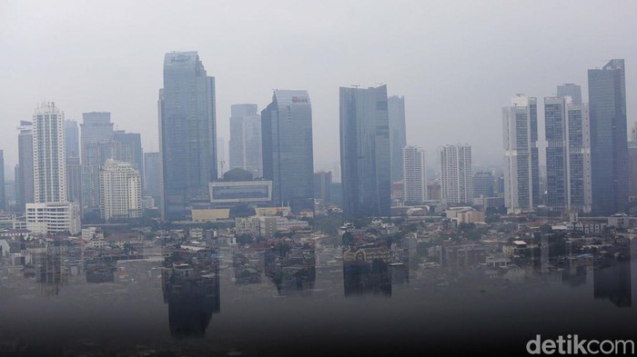 Deretan gedung pencakar langit Jakarta tertutup kabut tipis siang ini. Gedung berkabut di tengah risiko perlambatan pertumbuhan ekonomi Indonesia di 2023.
