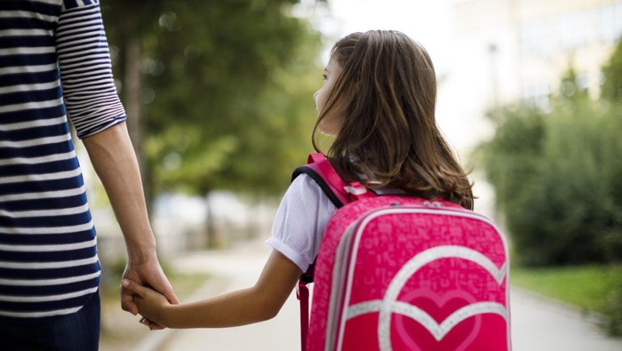 Mother taking her daughter to school