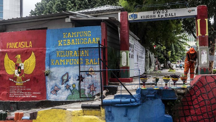 Kampung Bali Jakarta, Dulu Kumuh Kini Cantik Warga berjalan di dekat mural di kawasan RW 03 Kelurahan Kampung Bali, Jakarta, Senin (26/12/2022). Pemprov DKI Jakarta melaksanakan program penataan kampung kumuh yang terdapat di tiap kelurahan melalui penghijauan lingkungan, pembuatan mural edukasi, dan pengembangan potensi ekonomi warga setempat. ANTARA FOTO/Aprillio Akbar/tom.