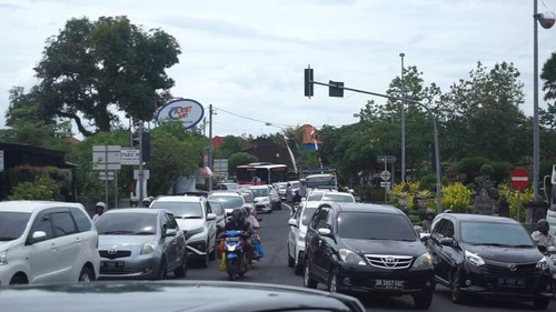 Kendaraan roda empat mendominasi ruas jalan satu arah di simpang Taman Rama Sinta, Desa Mengwitani, Kecamatan Mengwi, Badung, Senin (26/12/2022). (Agus Eka)
