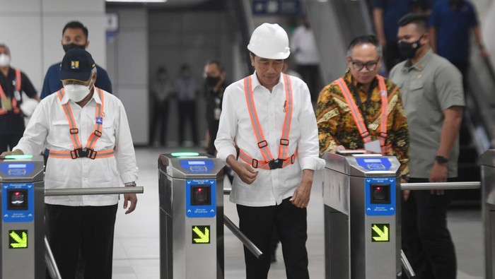 Presiden Joko Widodo (tengah) didampingi Menteri PUPR Basuki Hadimuljono (kiri) berjalan melintasi gerbang pembayaran di Stasiun Light Rail Transit (LRT) Taman Mini Indonesia Indah, Jakarta, Senin (26/12/2022). Presiden Joko Widodo berharap proyek LRT Jabodebek yang perkembangannya telah mencapai 85 persen itu bisa beroperasi dan digunakan masyarakat pada Juli 2023. ANTARA FOTO/Hafidz Mubarak A/wsj.