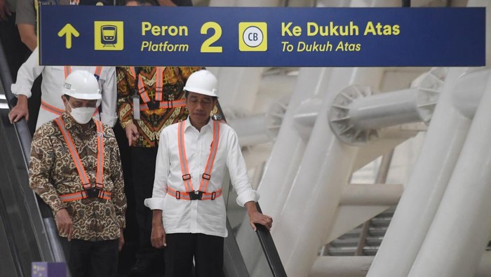 Presiden Joko Widodo (kanan) didampingi Menko Kemaritiman dan Investasi Luhut Binsar Pandjaitan (kiri) berjalan di area stasiun usai menumpang kereta Light Rail Transit (LRT) dari Stasiun Harjamukti di Stasiun Taman Mini Indonesia Indah, Jakarta, Senin (26/12/2022). Presiden Joko Widodo berharap proyek LRT Jabodebek yang perkembangannya telah mencapai 85 persen itu bisa beroperasi dan digunakan masyarakat pada Juli 2023. ANTARA FOTO/Hafidz Mubarak A/wsj.